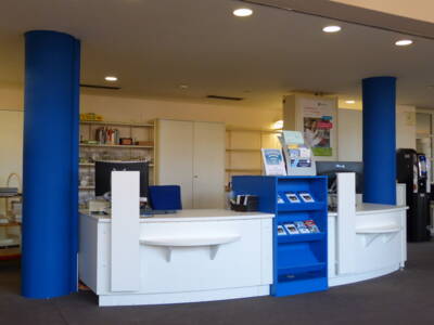 Blick auf den zwischen blaue Säulen stehenden Begrüßungsterminal der Bücherei
